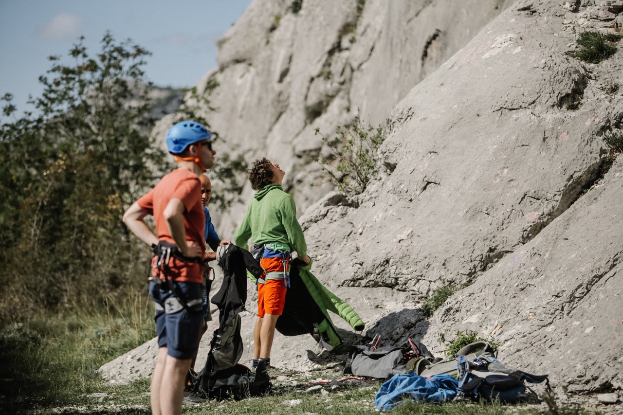 group of climbers preparing and looking up at a rocky cliff face